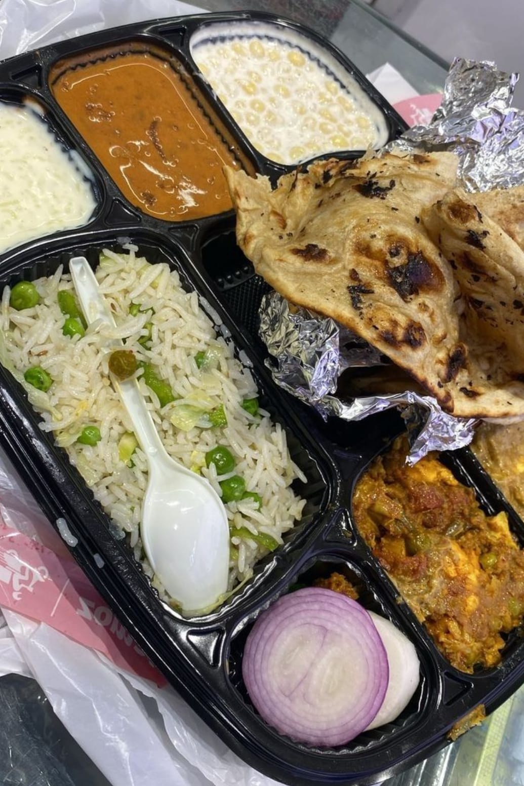 Fresh tiffin with pea rice, paratha, dal makhani, raita and paneer sabzi